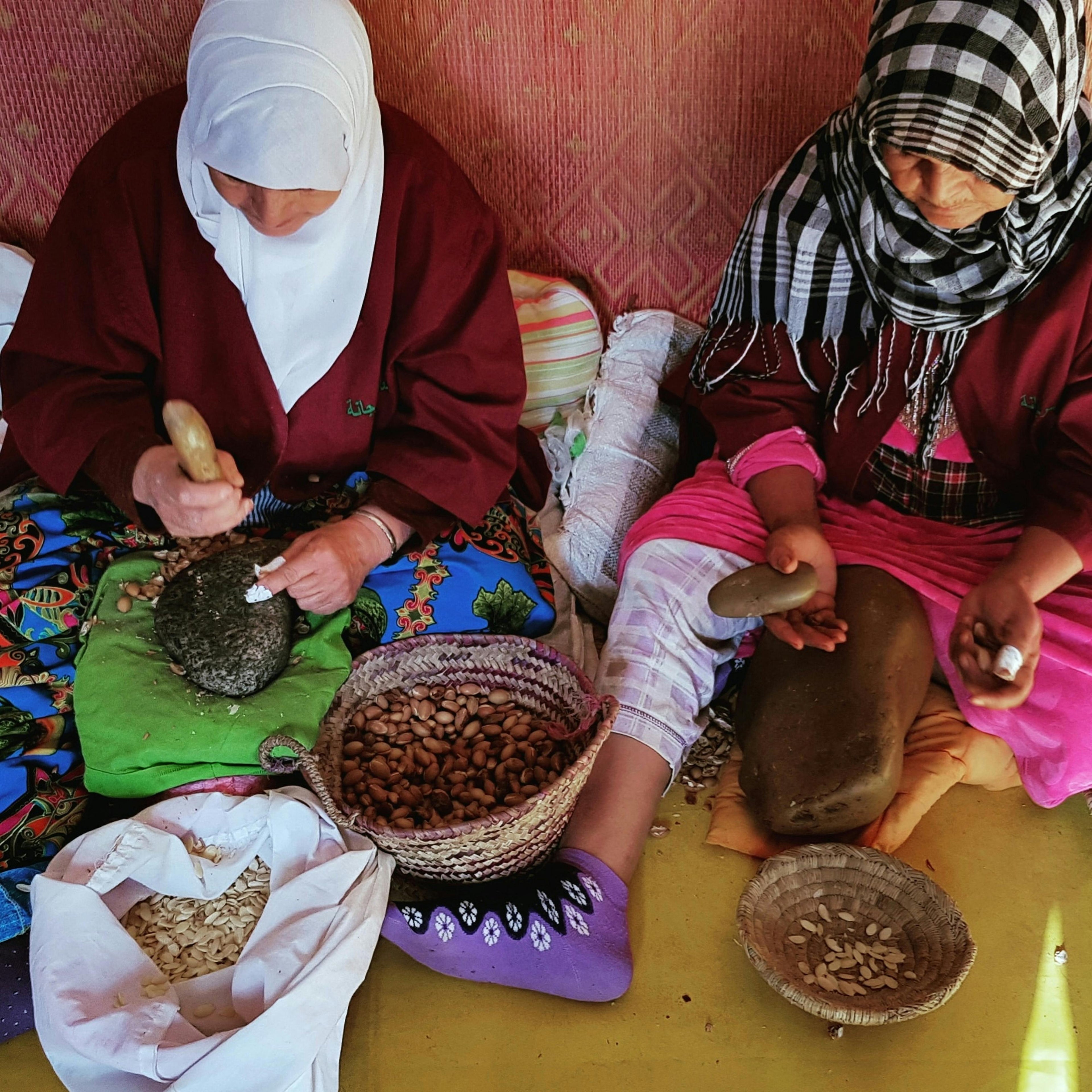 Femmes artisanes marocaines cassant les noix d'argan